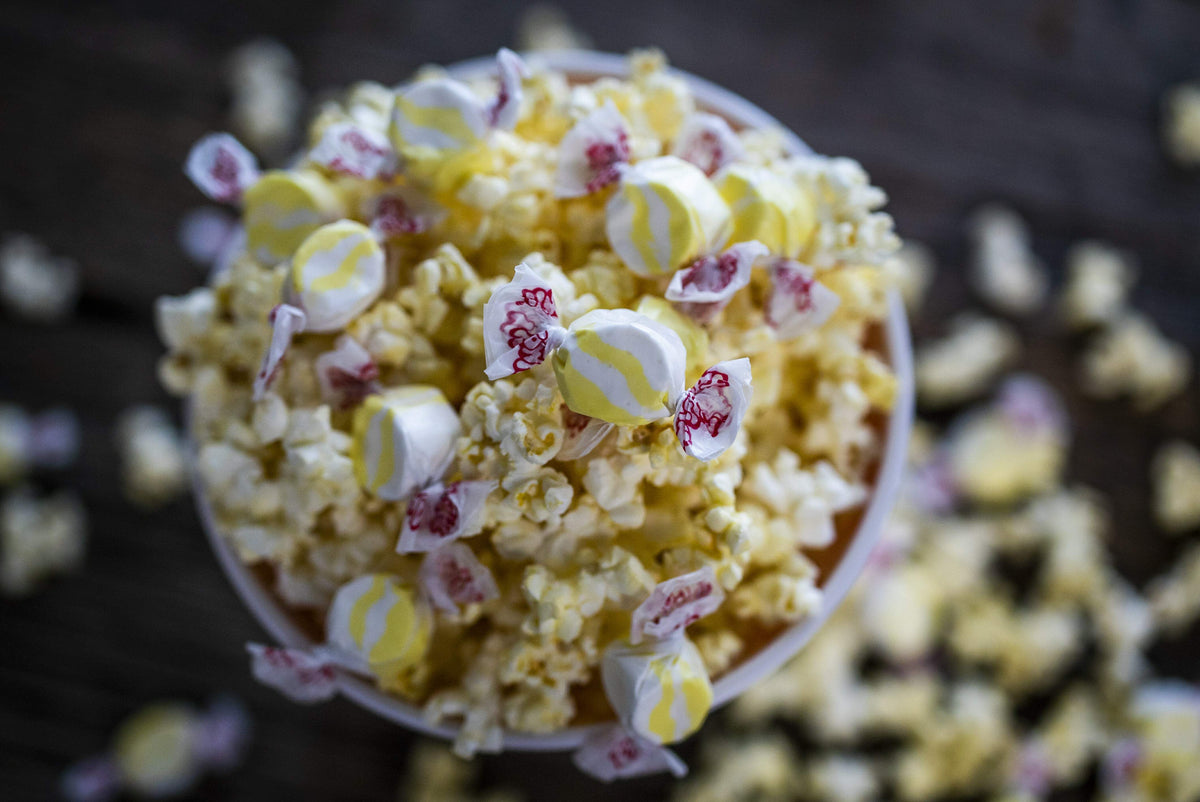 Taffy Town buttered popcorn salt water taffy candy nestled in a bowl of buttery popcorn for movie night snacking